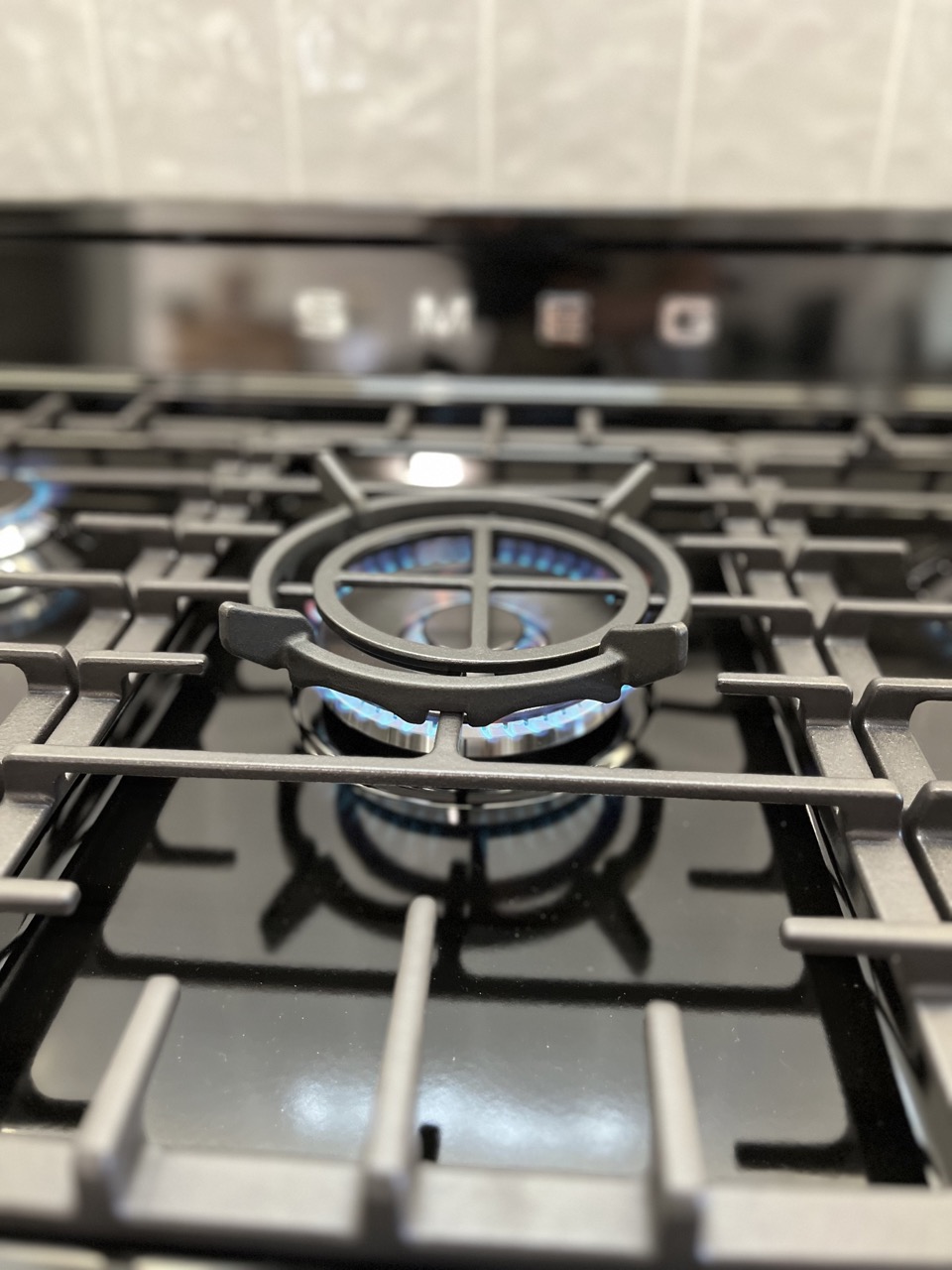 Gas cooktop burner lit with an even blue flame