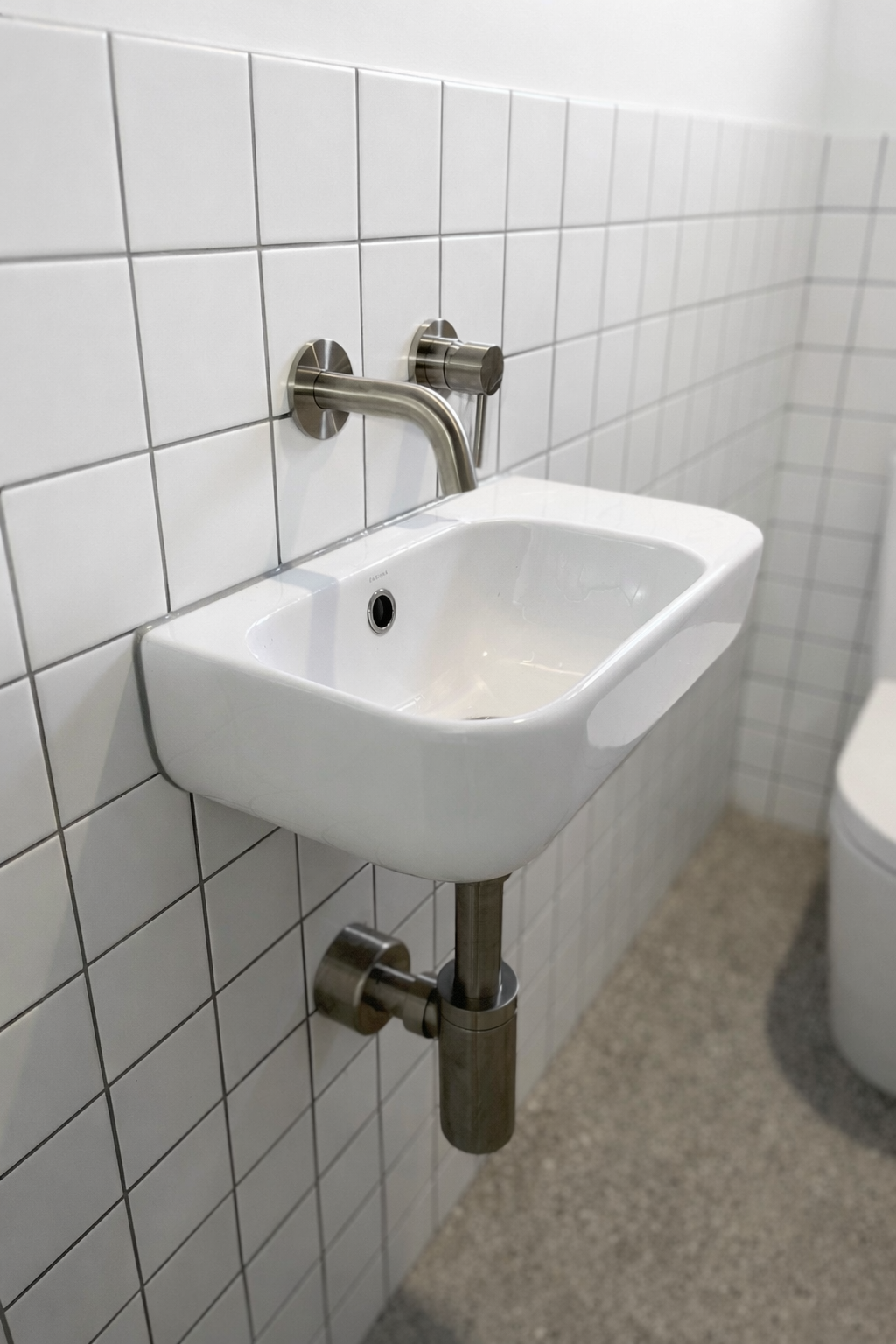 Wall-hung basin with brushed nickel wall mixer